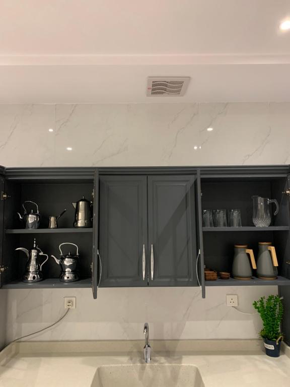 a kitchen with black cabinets with pots and pans at سيلينا هاوس in Jeddah
