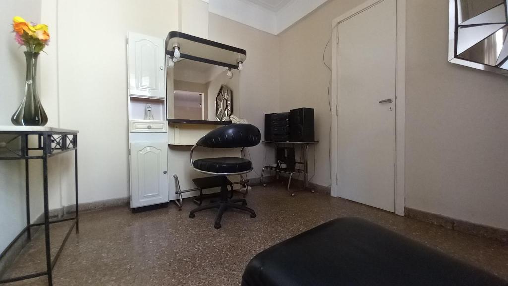 Habitación con silla negra y nevera. en Departamento Amplio 3 ambientes - Belgrano en Buenos Aires