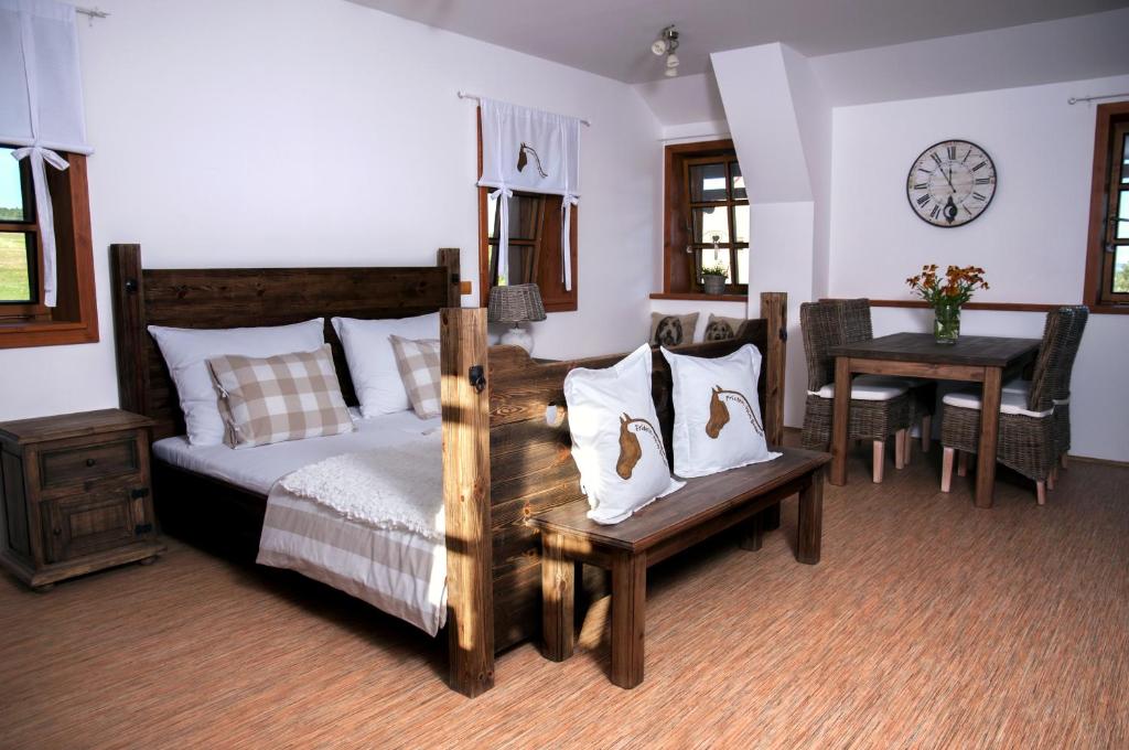 a bedroom with a bed and a table and chairs at Penzion Jízdárna Hejtmánkovice in Broumov