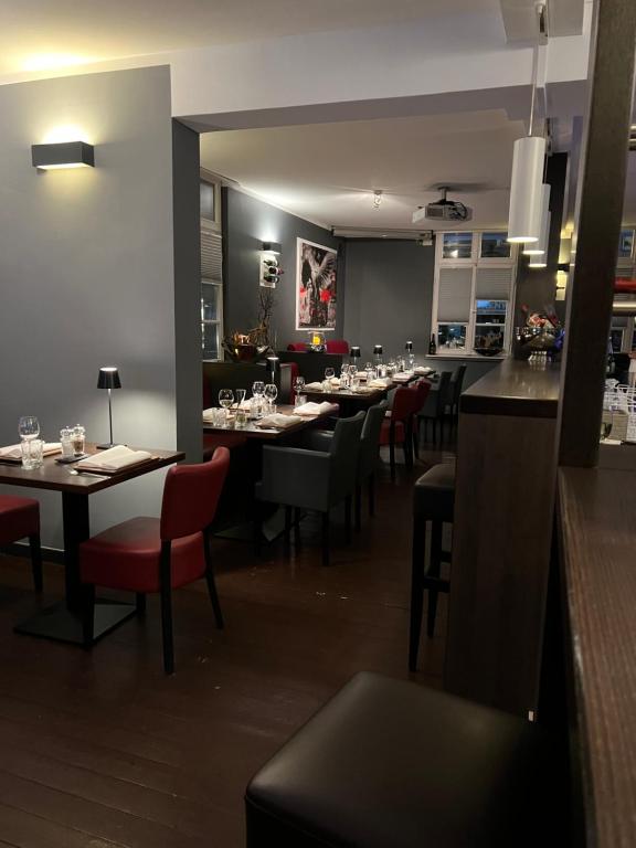 un comedor con mesas y sillas rojas en Hotel zum Postwagen en Gevelsberg
