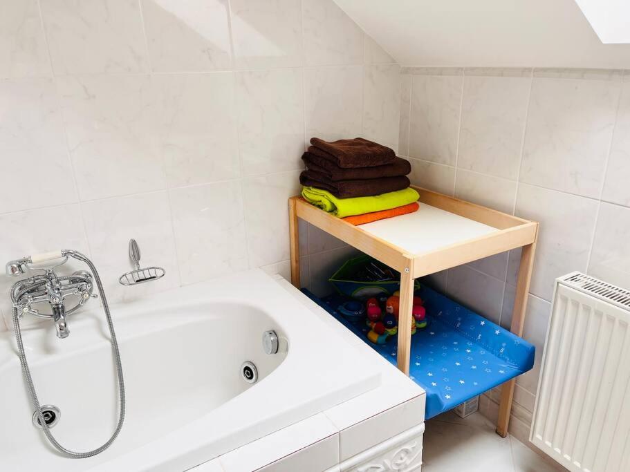 baño con bañera y mesa con toallas en Apartmán se zahradou 20 minut do centra Prahy, en Ořech