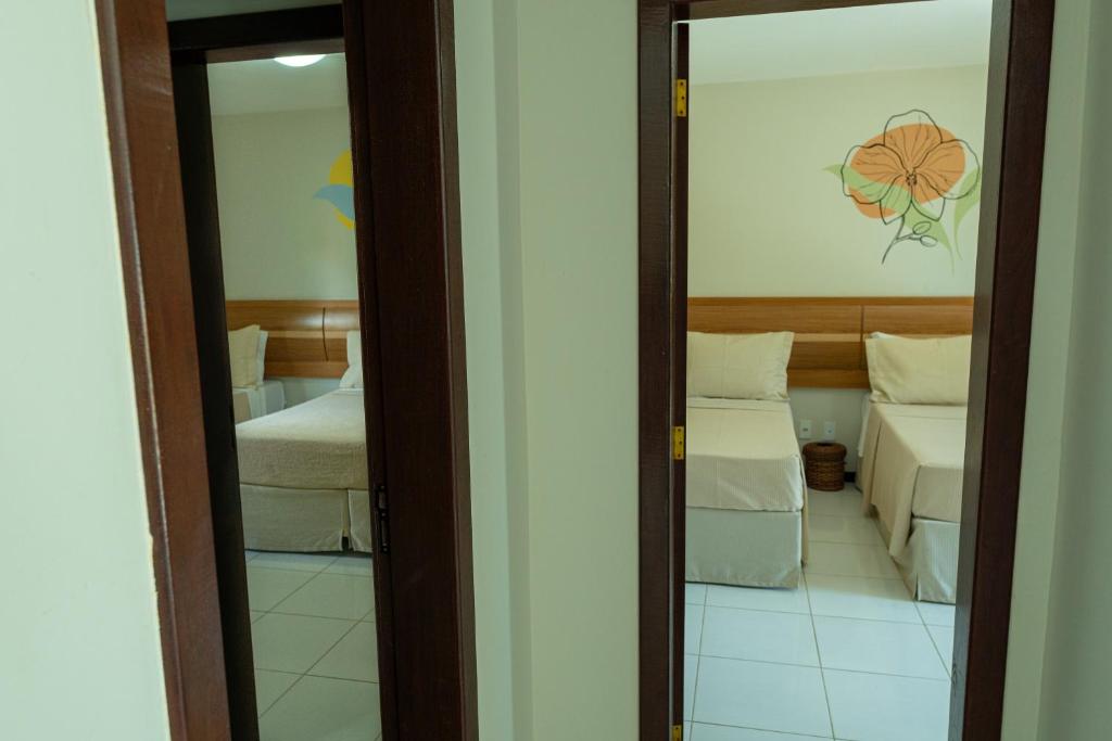 Postel nebo postele na pokoji v ubytování Orquídeas Praia Hotel
