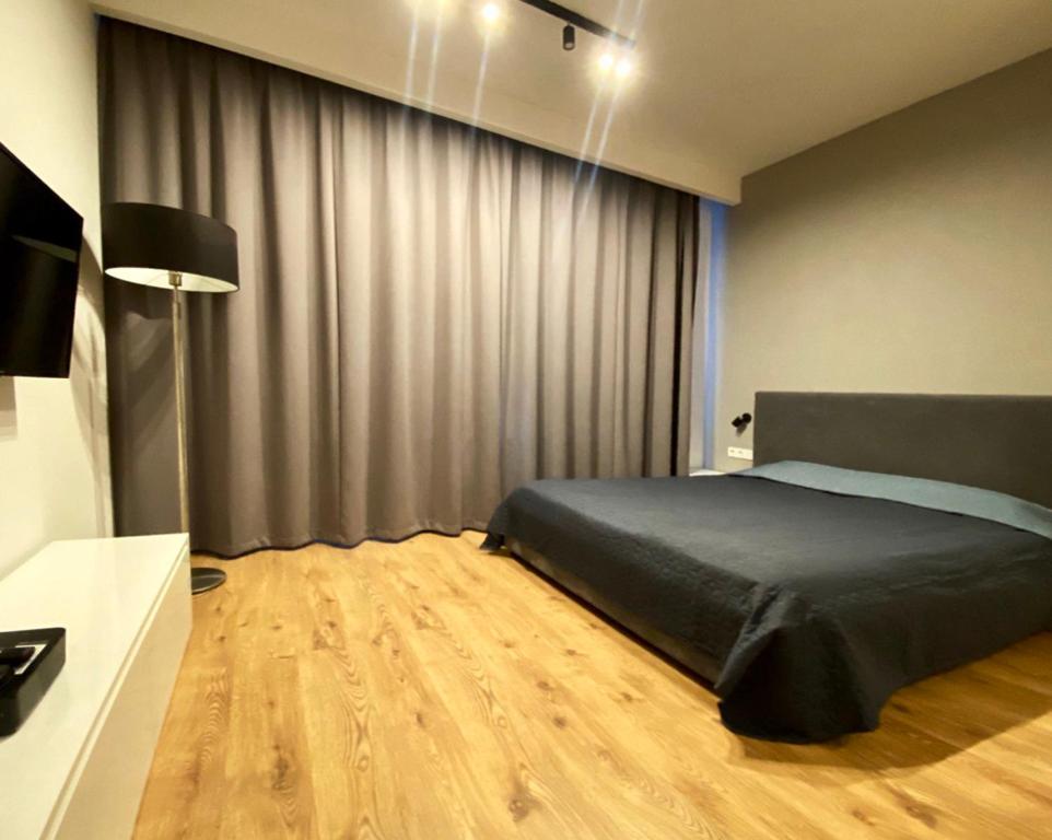 sypialnia z łóżkiem i biurkiem z telewizorem w obiekcie K22 Apart in Warsaw Slawinska 505 w Warszawie