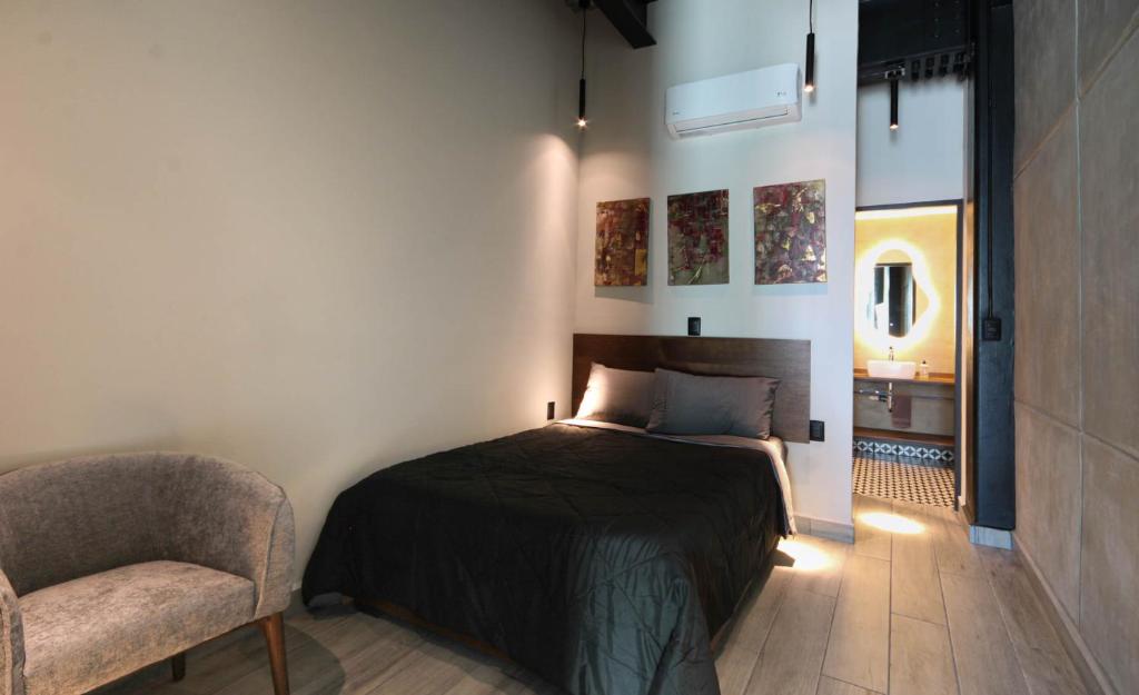 a bedroom with a bed and a chair in a room at Hermoso y cómodo mini LOFT 3 in Mexico City