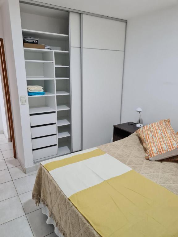 1 dormitorio con cama y armario en departamento maipu en Salta