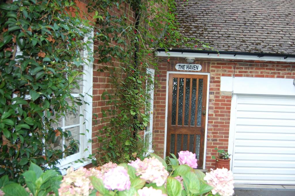 una casa de ladrillo con una puerta y flores en The Haven at Talysarn, en Ascot