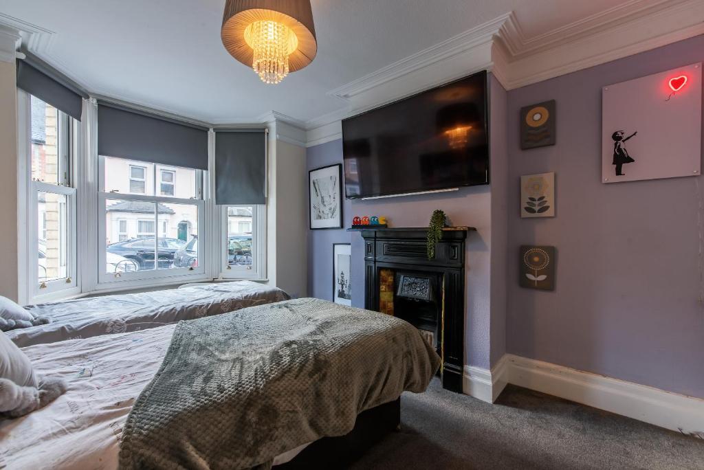 a bedroom with two beds and a fireplace and a tv at Springfield Place - 3 Bed Central Reading - Sleeps 6 - Free Parking in Reading