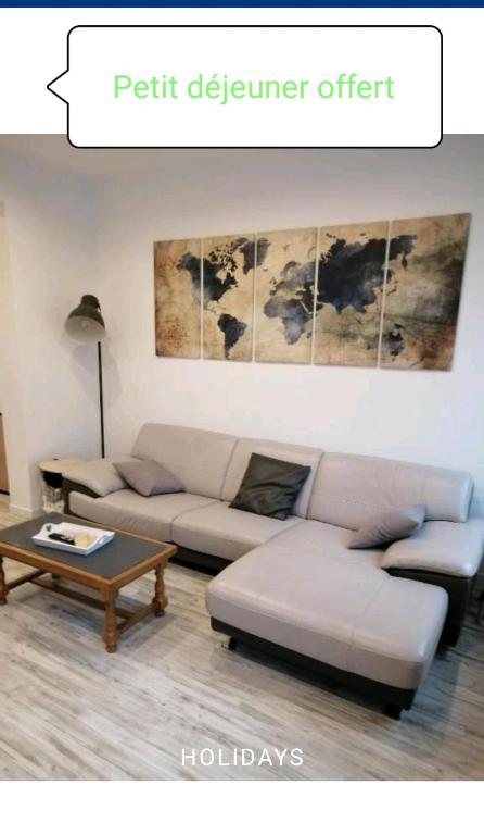 un salon avec un canapé et une table basse dans l'établissement La maison du bonheur, à Calais