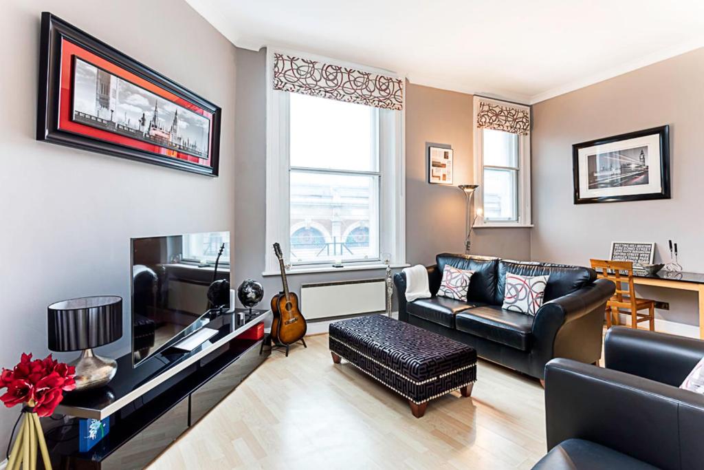 a living room with a couch and a tv at Chic Farringdon Flat in London