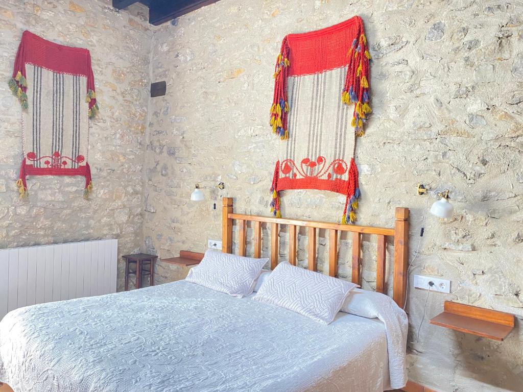 1 dormitorio con 1 cama y 2 ventanas de color rojo en Casa Sara, en Cantavieja