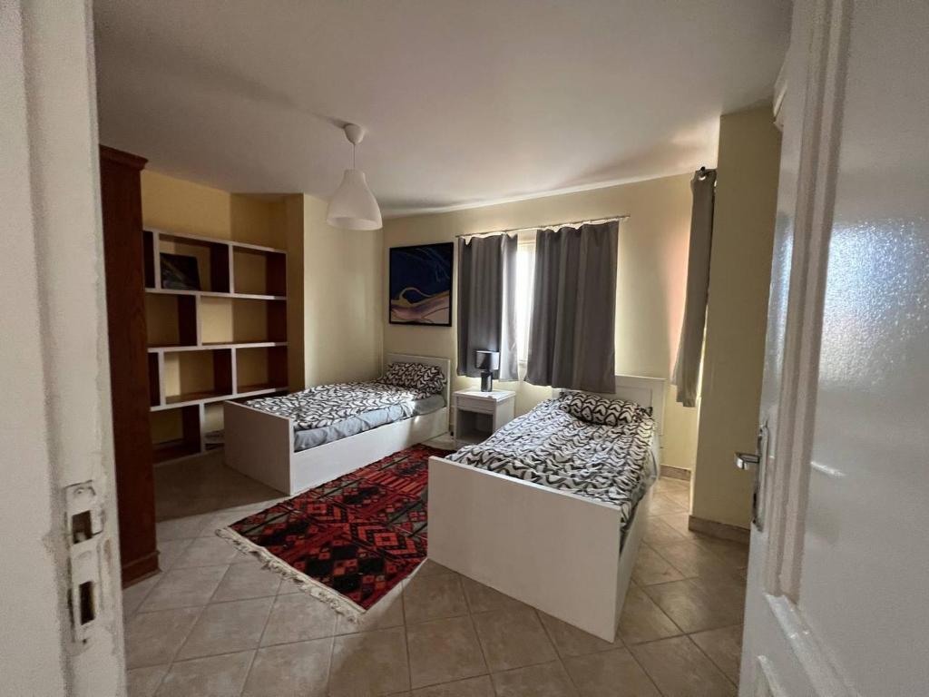 Habitación con 2 camas y alfombra. en Ella villa21, en Sharm El Sheikh