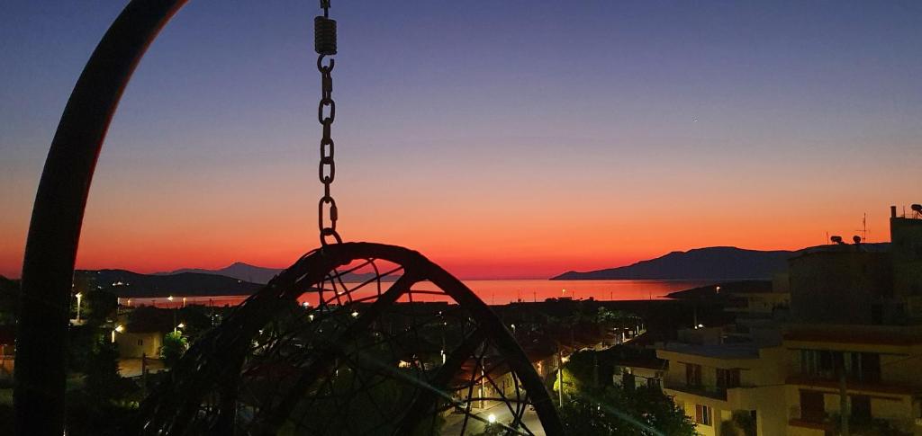 a swing at a carnival with the sunset in the background at Sea & Mountain Apartment in Lávrion