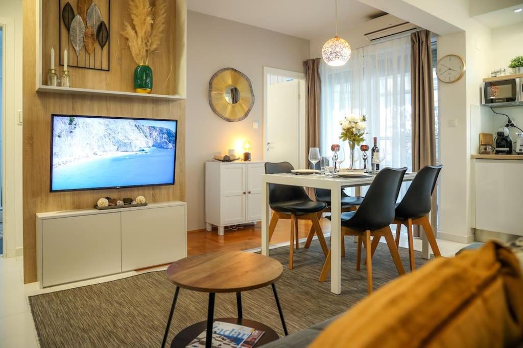 a living room with a dining table and a tv at Apartment Mare Blu in Kožino