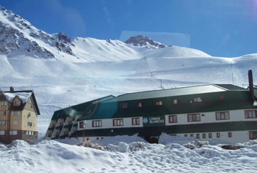 Un treno nella neve vicino a una montagna di Departamento Penitentes Lomas Blancas a Los Penitentes