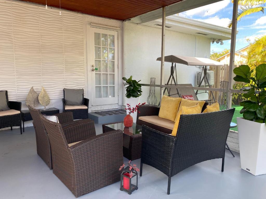 um pátio com cadeiras de vime e uma mesa em Modern Home, Excellent Location Miami em Miami