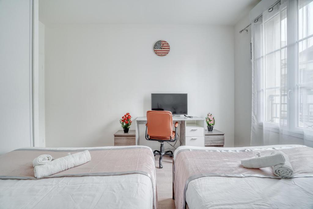a bedroom with two beds and a desk with a computer at Cozy - Free Parking - 15mn from Paris Montparnasse in Clamart