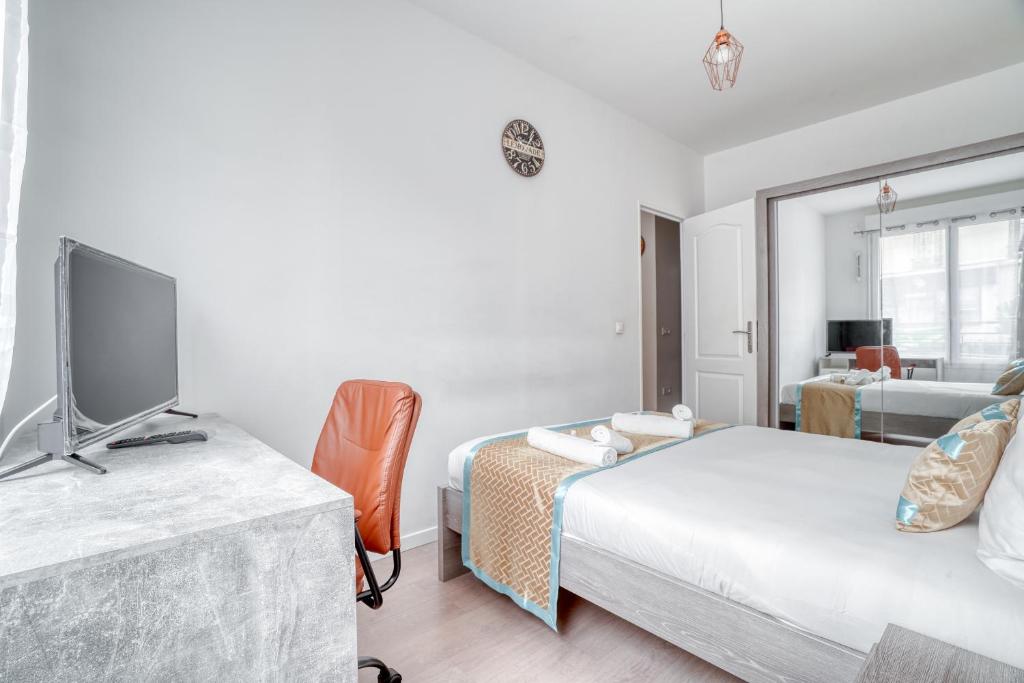 a bedroom with two beds and a television in it at Cozy - Free Parking - 15mn from Paris Montparnasse in Clamart