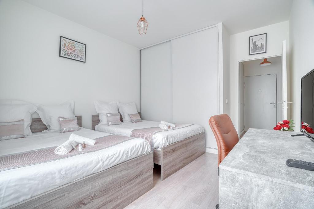 a white room with two beds and a table at Cozy - Free Parking - 15mn from Paris Montparnasse in Clamart