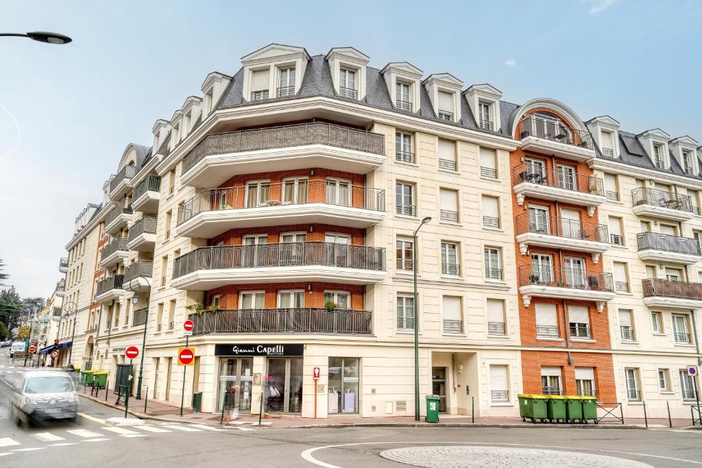 a large building on the corner of a street at Cozy - Free Parking - 15mn from Paris Montparnasse in Clamart