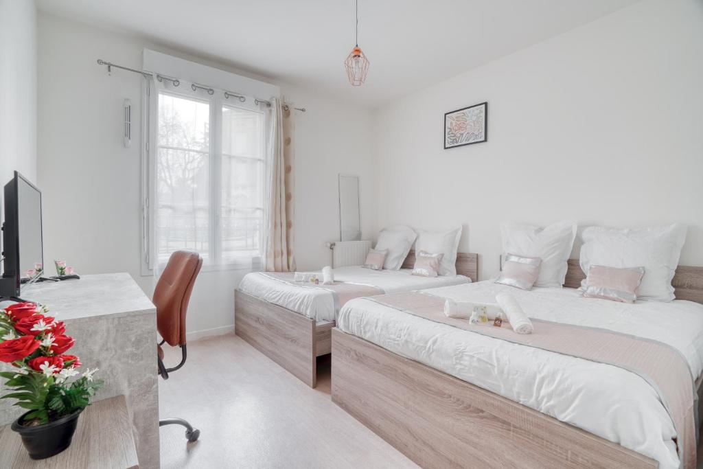 two beds in a white room with a table and a desk at Cozy - Free Parking - 15mn from Paris Montparnasse in Clamart