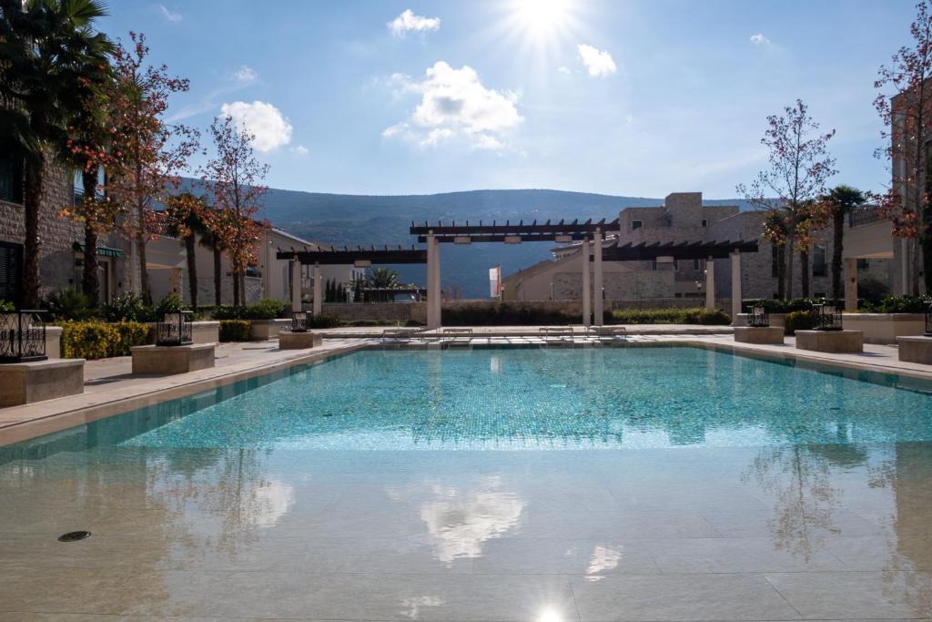 a large swimming pool in a building with a sky at Paloma Apartment - Portonovi Resort in Herceg-Novi