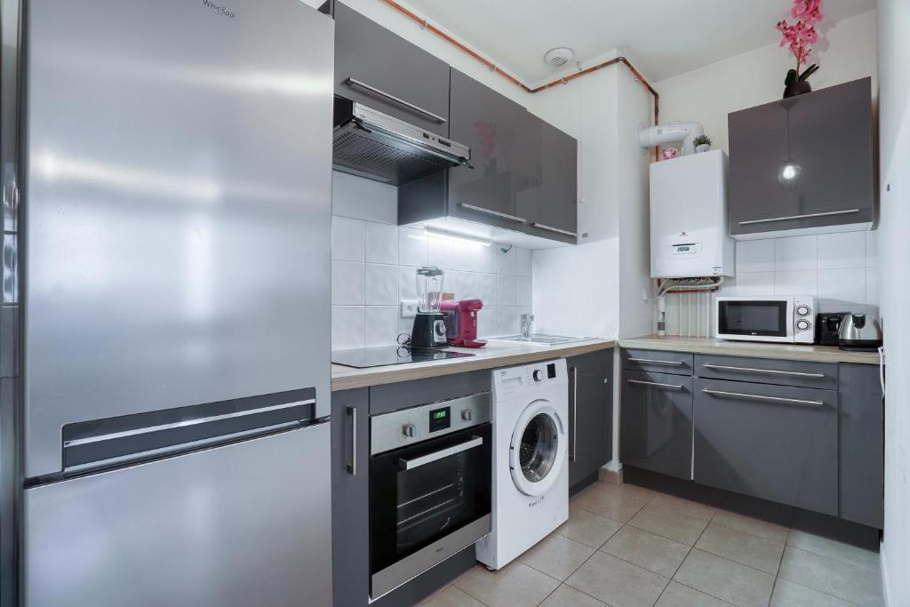 a kitchen with a washing machine and a washer at Cozy - Free Parking - 15mn from Paris Montparnasse in Clamart
