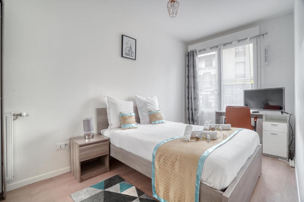 a white bedroom with a bed and a tv at Cozy - Free Parking - 15mn from Paris Montparnasse in Clamart