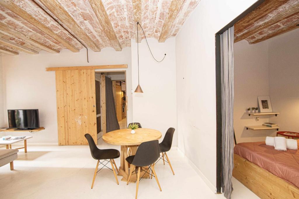 una camera con tavolo, sedie e letto di Bonito apartamento en el Barri Vell Girona a Girona