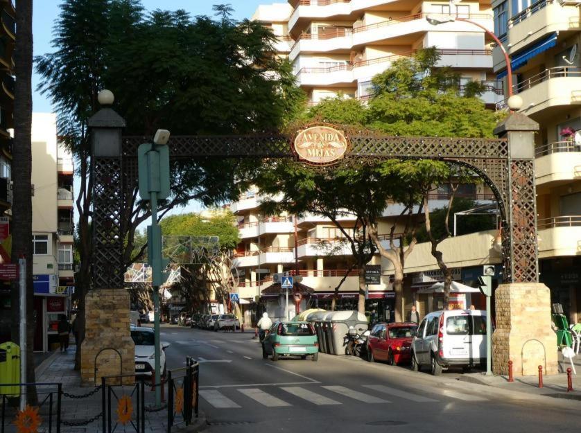 un arco sobre una calle de la ciudad con coches aparcados en la calle en Habitación independiente céntrica en Fuengirola