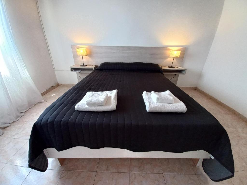 1 dormitorio con 1 cama grande y 2 toallas. en Alojamientos Litoral - Casa del Sol en Gualeguaychú