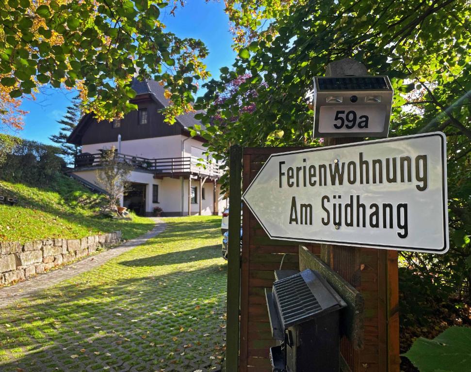 un letrero de la calle frente a una casa en Ferienwohnung-Am-Suedhang en Müglitztal
