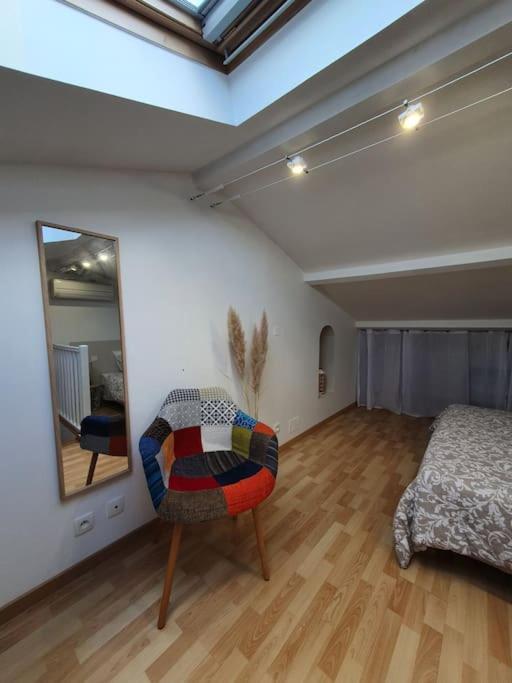 Habitación con cama, silla y espejo. en L'Abri Côtier, l'appart 60m2, 1 chb avec terrasse, en Caux