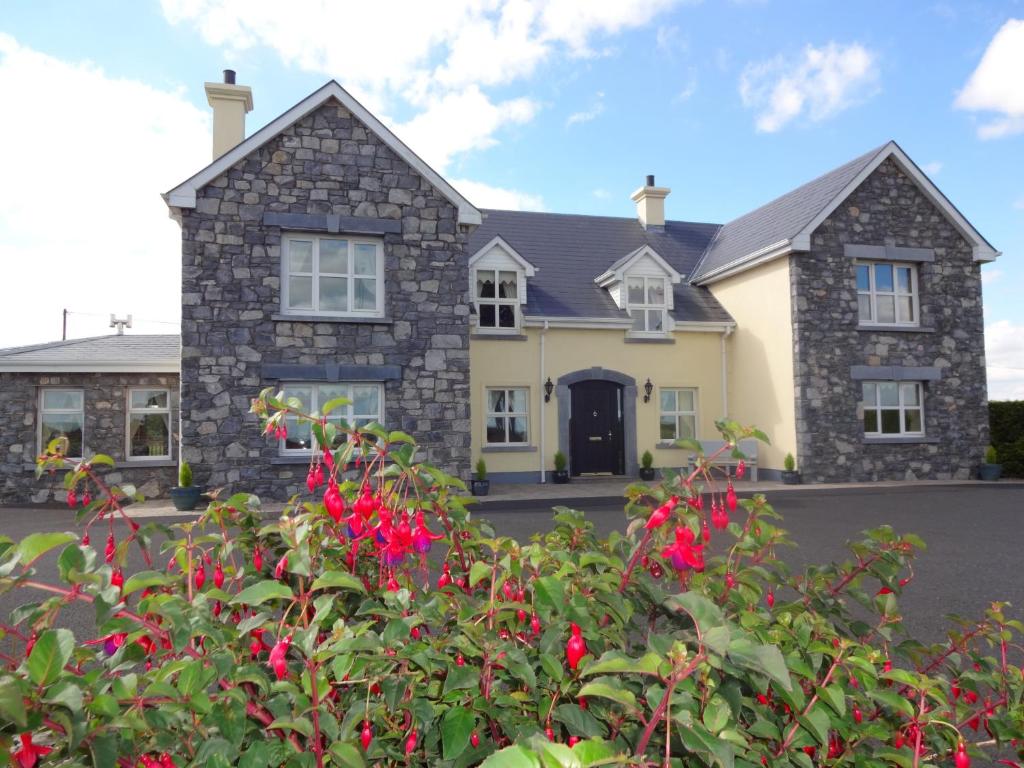 uma casa com flores vermelhas em frente em Bunratty Haven em Bunratty