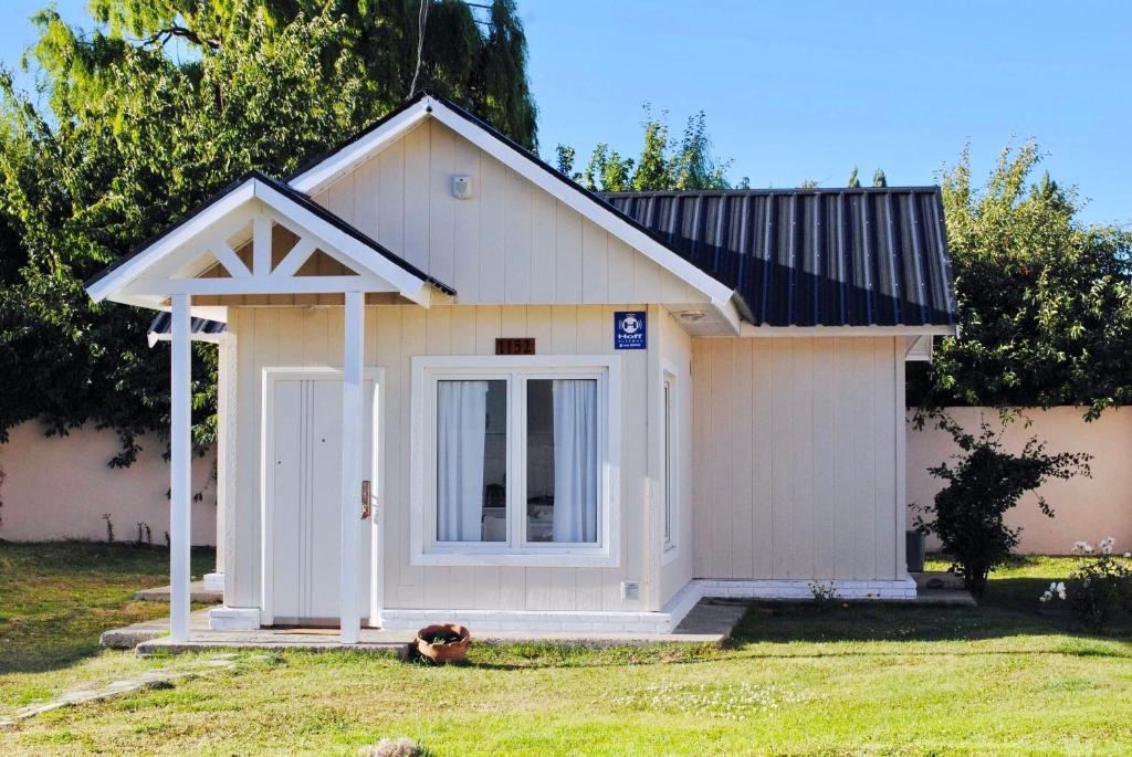 una pequeña casa de perros blancos con techo de gambrel en Calafate Drome en El Calafate