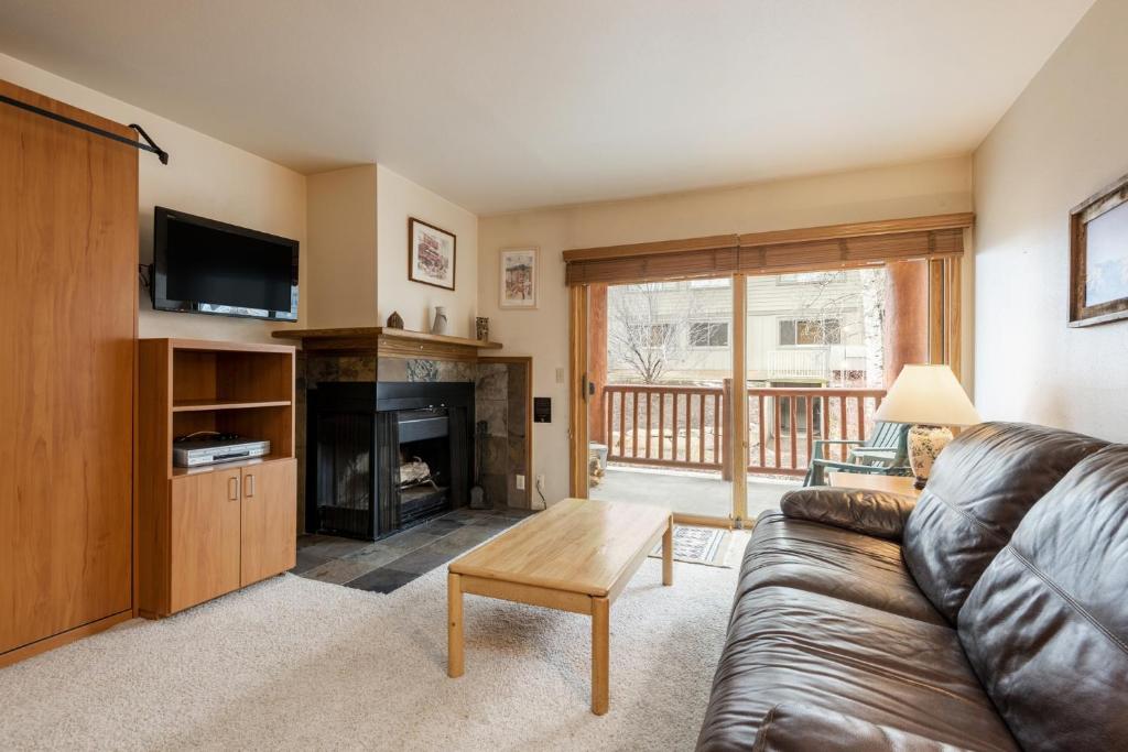 a living room with a couch and a fireplace at SNOW FLOWER 066-Studio condo in Park City