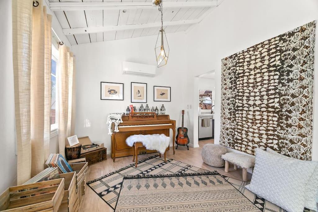 een woonkamer met een piano en een stoel bij The Desert Nomad Retreat in Joshua Tree Village in Joshua Tree