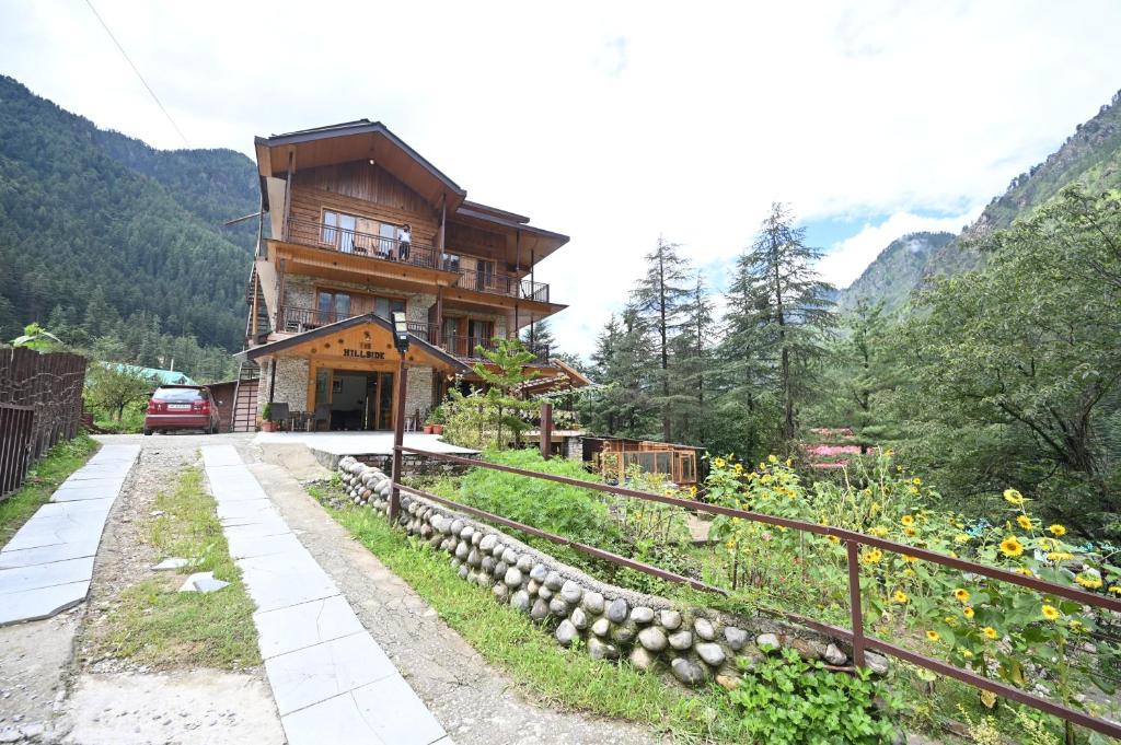 a house on a hill with a road in front of it at The Hillside in Kasol