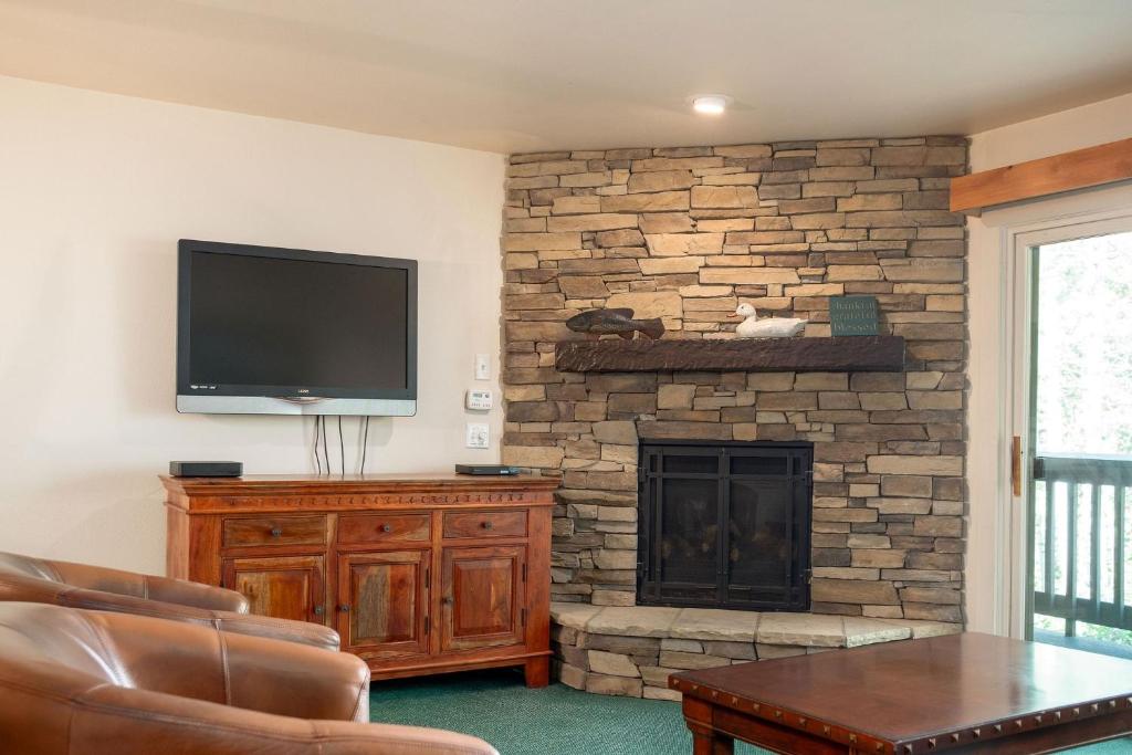 ein Wohnzimmer mit einem TV und einem Kamin in der Unterkunft SNOW FLOWER 149 condo in Park City