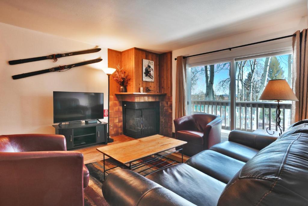 a living room with a couch and a fireplace at SNOW FLOWER 104 condo in Park City