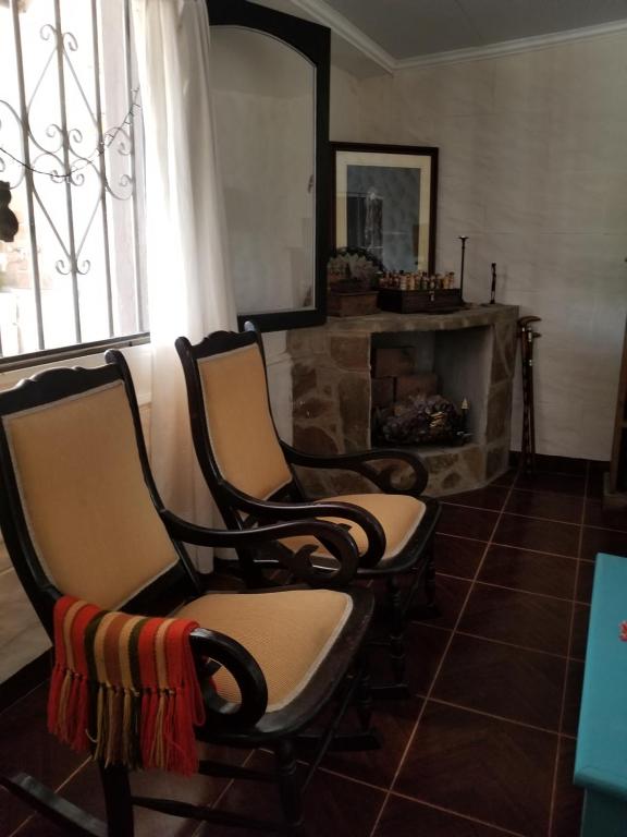 sala de estar con 2 sillas y chimenea en La Soñadita en Salta