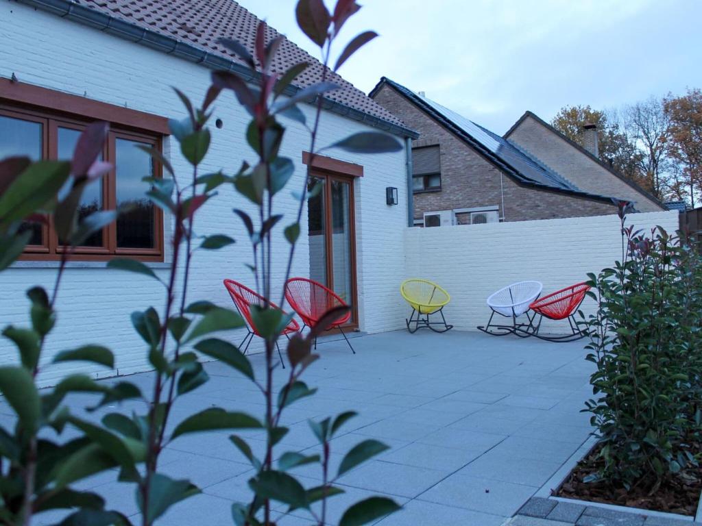 eine Terrasse mit 4 Stühlen und einem Zaun in der Unterkunft Attractive bungalow in Lanaken with fenced garden in Lanaken