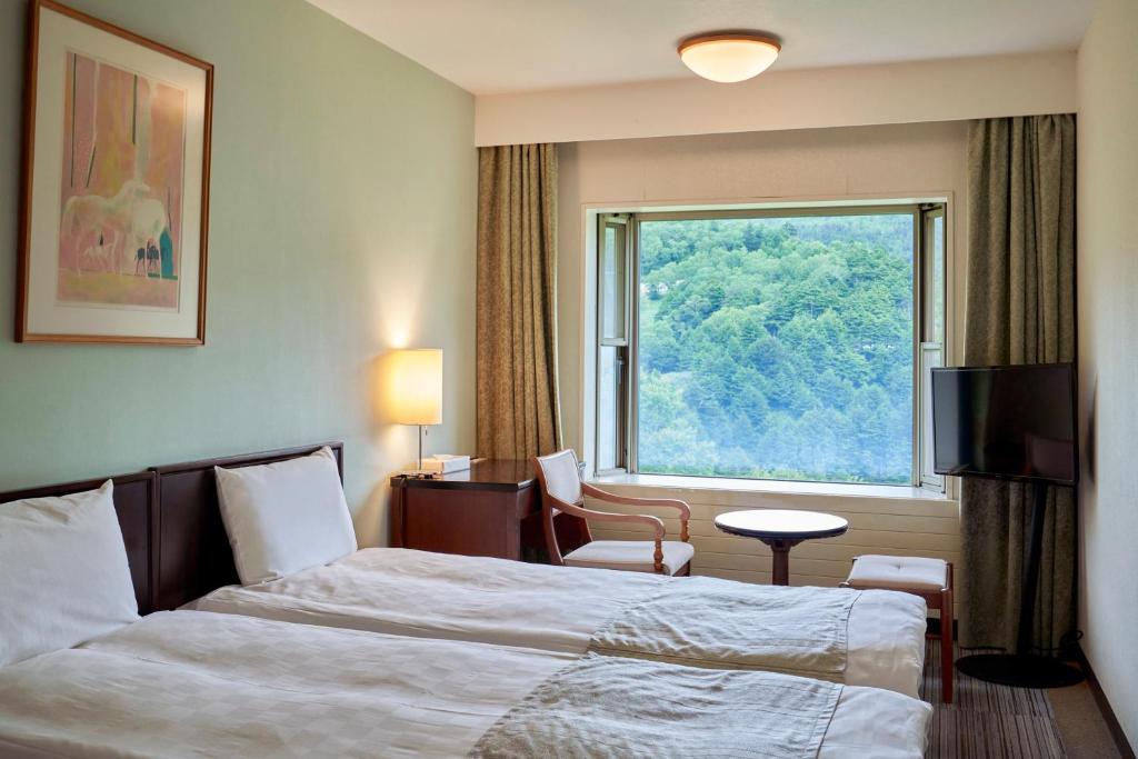 Postel nebo postele na pokoji v ubytování Manza Prince Hotel
