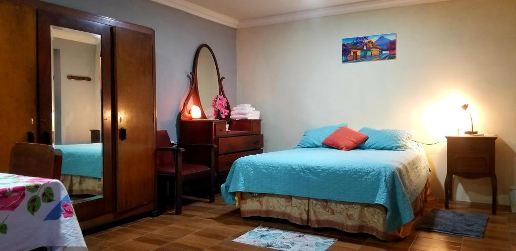 um quarto com uma cama, uma cómoda e um espelho em Xelanos em Quetzaltenango