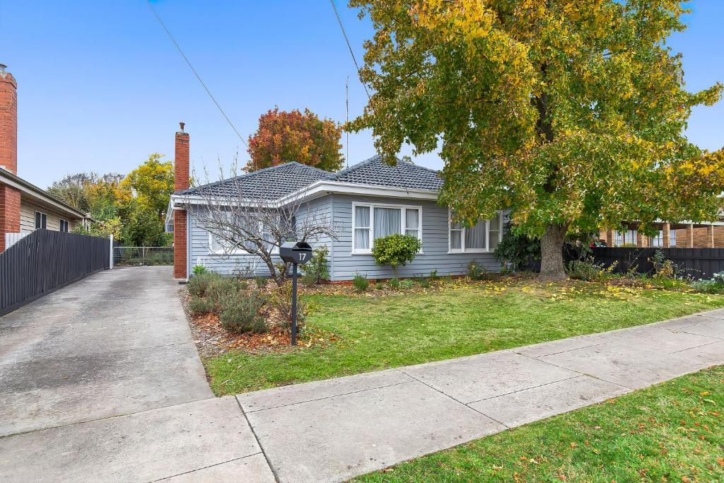 a white house with a tree in the yard at Longley Place in Alfredton