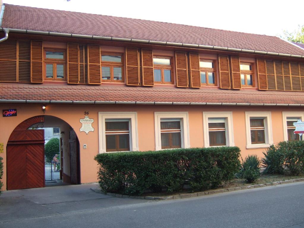 a building with a brown door and wooden windows at Tímárház Panzió in Szeged