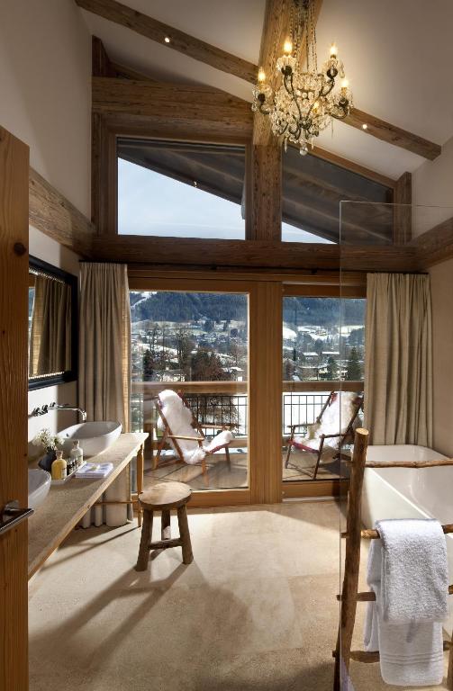 a living room with a large window and a table and chairs at Kitzhof Mountain Design Resort in Kitzbühel