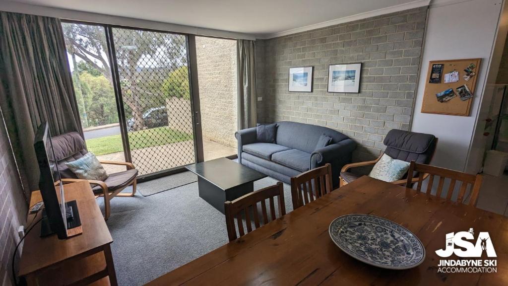 a living room with a table and a couch at Tanderra 4 in Jindabyne