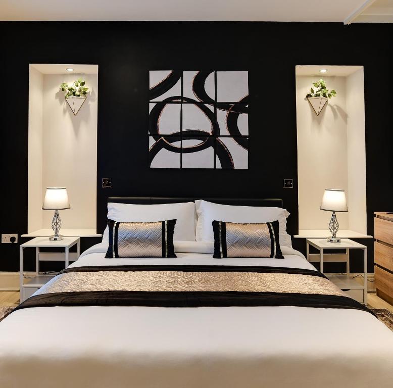 een slaapkamer met een groot wit bed met twee lampen bij InstaLet Apartments I Wigan Central I Free Parking in Wigan