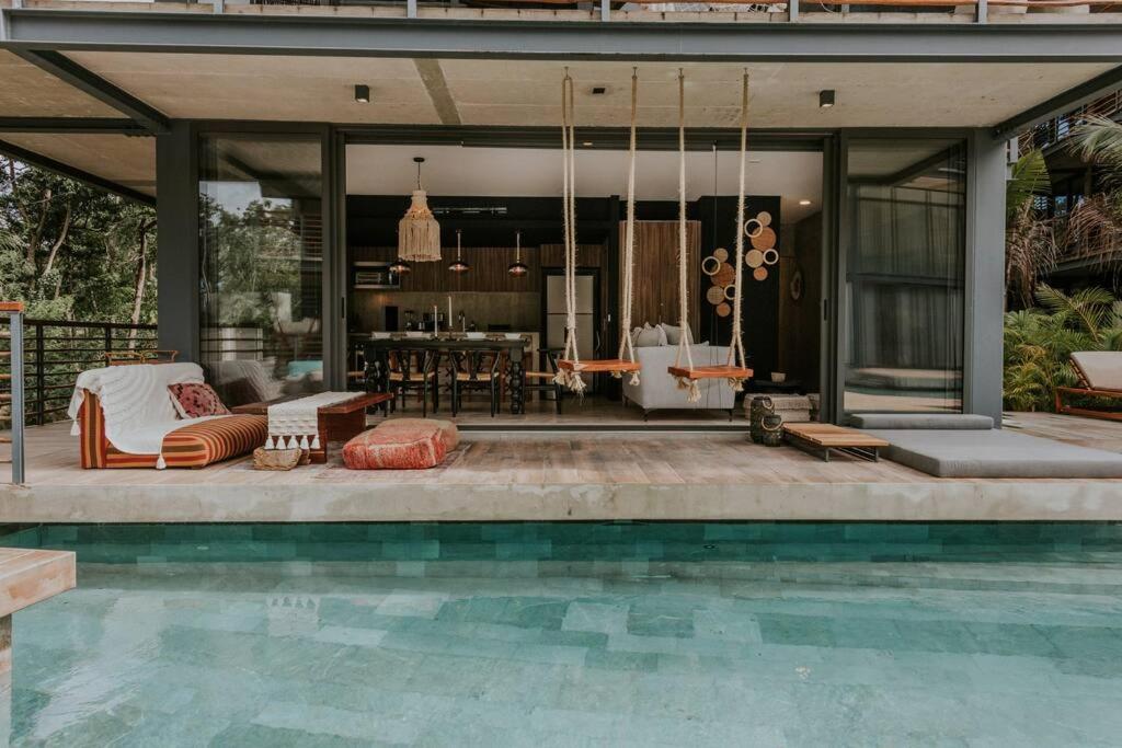 a house with a swimming pool next to a house at Cenote + Swim-Up + Luxury Condo in Tulum