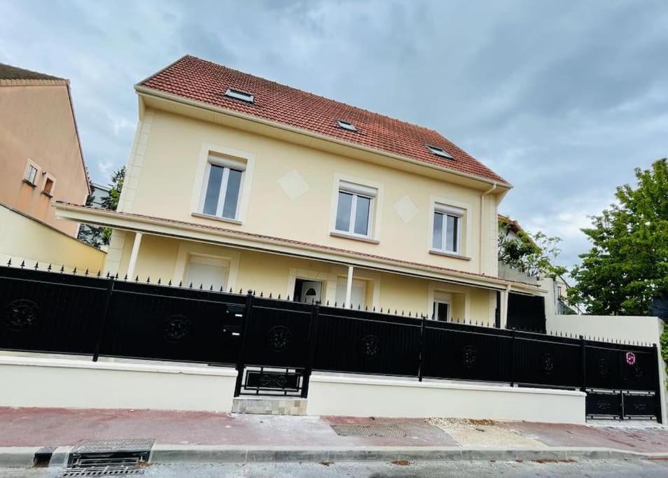a house with a black fence in front of it at Best holliday Home for family newly renovated in Garges-lès-Gonesse